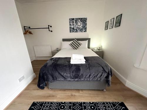 a bedroom with a bed with a black and white comforter at Wenlock Liverpool in Liverpool