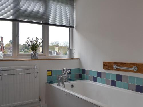 baño con bañera y ventana en Sea Breezes, en Totland