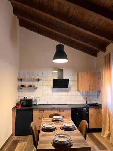 a kitchen with a wooden table with chairs and aendant light at Casas del Barranco de la Hoz in Ventosa