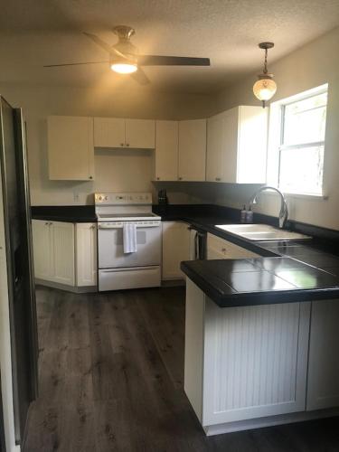 a kitchen with white cabinets and a white stove top oven at Luxurious indoor/outdoor Family Paradise in downtown St Augustine in St. Augustine