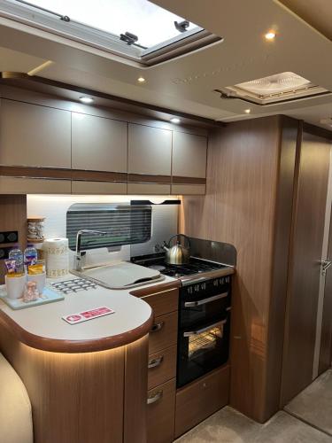 a kitchen with a stove and a counter top at Self Contained Holiday Home Caravan in Corsham