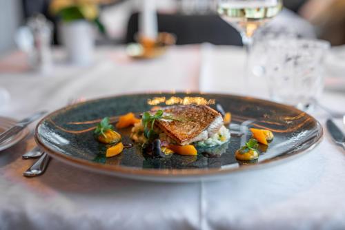 a plate with a sandwich and vegetables on a table at Naturhotel Tandler in Sankt Jakob in Defereggen
