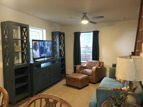 - un salon avec une télévision, un canapé et une chaise dans l'établissement Luxurious indoor/outdoor Family Paradise in downtown St Augustine, à Saint Augustine