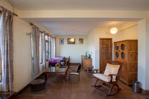 a living room with a table and chairs at Naddi Castle in McLeod Ganj