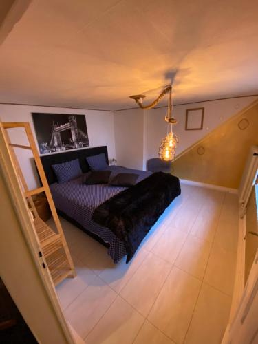 um quarto com uma cama e uma escada num quarto em House in Eislek, North Luxembourg, dating from 1890, newly renovated 