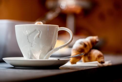 a coffee cup and a plate with a piece of food at Naturhotel Tandler in Sankt Jakob in Defereggen
