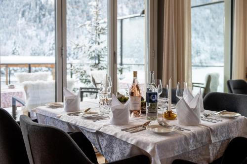 a table with a white table cloth and wine bottles at Naturhotel Tandler in Sankt Jakob in Defereggen