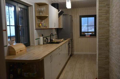 a kitchen with white cabinets and a wooden counter top at Pod Zielonym Dachem in Kamienna Góra