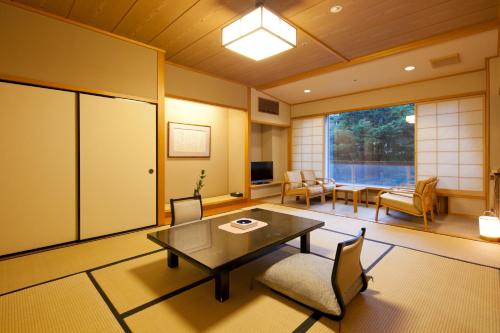 a living room with a table and chairs and a window at Zazan minakami in Minakami