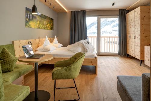 pokój hotelowy z łóżkiem i stołem z laptopem w obiekcie Naturhotel Tandler w mieście Sankt Jakob in Defereggen