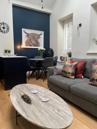 un soggiorno con divano e tavolo di Grayling Cottage ad Ambleside