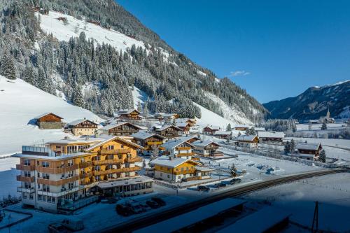 a resort in the mountains with snow on the ground at Naturhotel Tandler in Sankt Jakob in Defereggen
