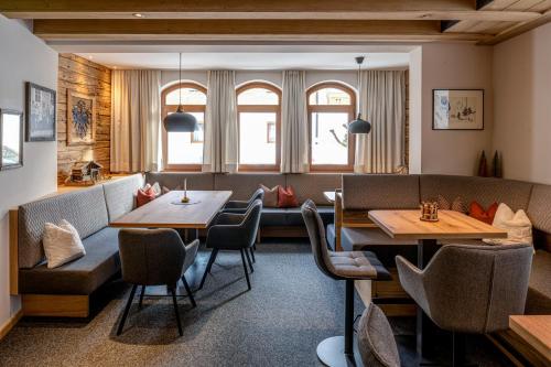 a restaurant with tables and chairs in a room at Naturhotel Tandler in Sankt Jakob in Defereggen