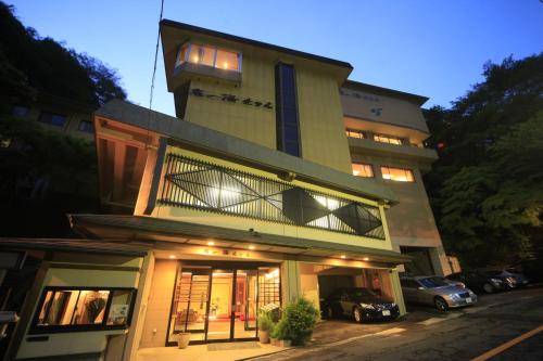 a building with cars parked in front of it at Shikanoyu Hotel in Komono