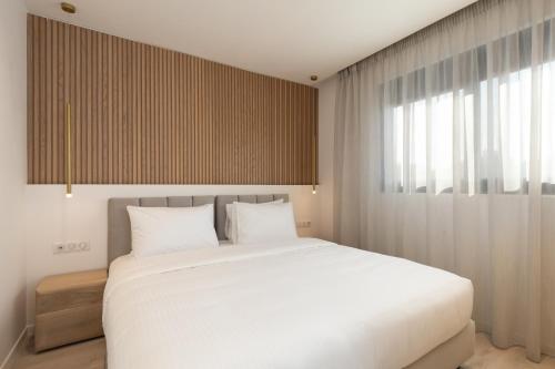 a bedroom with a large white bed and a window at Incanto Boutique Suites - Neos Kosmos in Athens