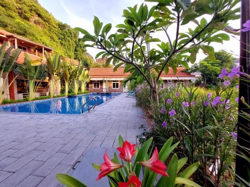 a resort with a swimming pool and some flowers at Ninh Binh Mountain Side Homestay & Cafe in Ninh Binh