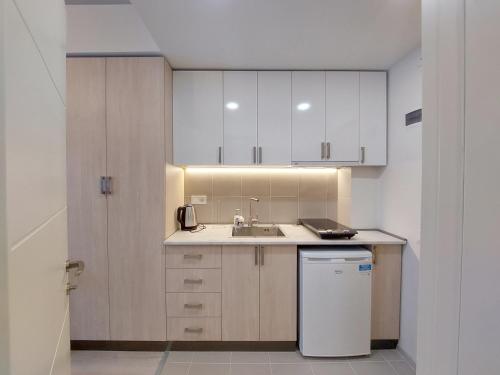 Una pequeña cocina con gabinetes blancos y un fregadero. en Bakuriani Mix Apartment 207, en Bakuriani