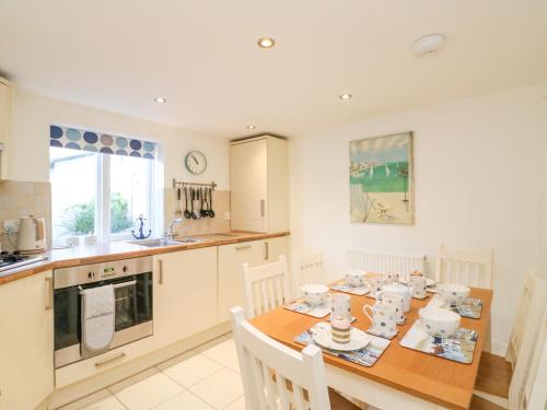 a kitchen with a wooden table with chairs and a dining room at Lobster Cottage in Weymouth