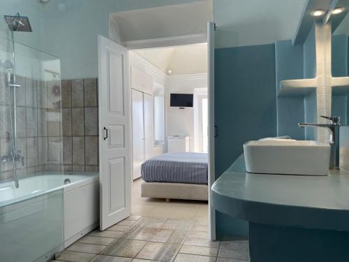 baño con lavabo, bañera y cama en Alexander Villas en Imerovigli