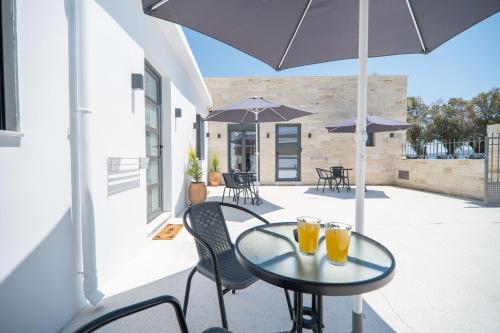 dos vasos de zumo de naranja sentados en una mesa en un patio en Kiani Apts, en Kalyves