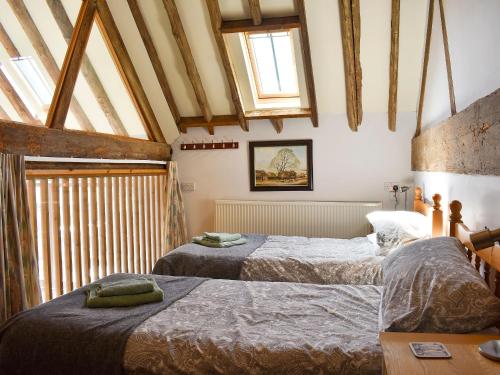 two beds in a room with wooden beams at The Barn - 19202 in Compton