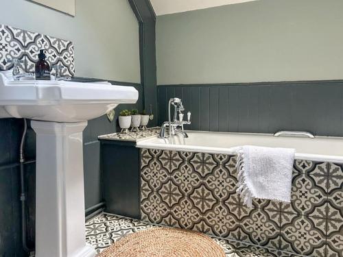 ein Badezimmer mit einem Waschbecken und einer Badewanne in der Unterkunft Creag Darach Cottage in Aberfoyle