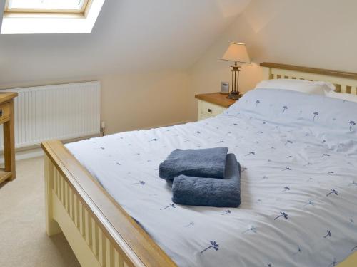 a bedroom with a large bed with a blue chair on it at The Lodge in Wedmore