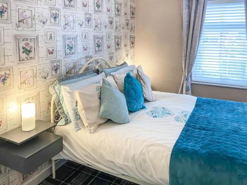 クリーブリーズにあるJasmins Retreatのベッドルーム1室(青と白の枕が備わるベッド1台付)