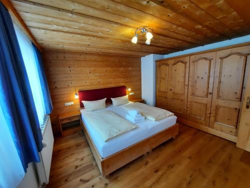 1 dormitorio con 1 cama en una habitación de madera en Ferienwohnung Drexel, en Steeg