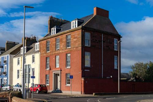 a large red brick building with a black roof at 1 Shore in Arbroath