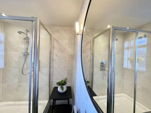 a bathroom with a shower and a tub at The Cove in Deal