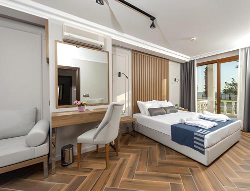 Un dormitorio con una cama, un escritorio y un espejo. en LUCAS DIDIM RESORT, en Yenihisar