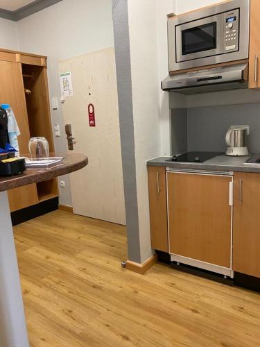 an empty kitchen with a microwave and a counter at Apartment Hotel KRAL - BUSINESS HOTEL & SERVICED APARTMENTS in Erlangen