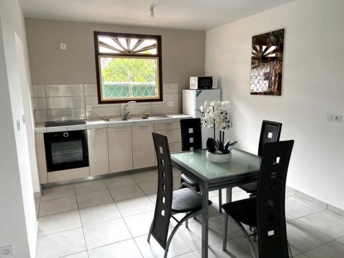 a kitchen with a table and chairs in a kitchen at Maison T3 neuve fonctionnelle in Matoury