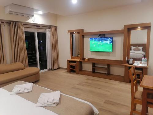 a hotel room with a television and a living room at Urban Boutique Hotel Pokhara in Pokhara