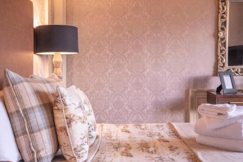 a bedroom with a bed with a lamp and a mirror at The Allan Park in Stirling