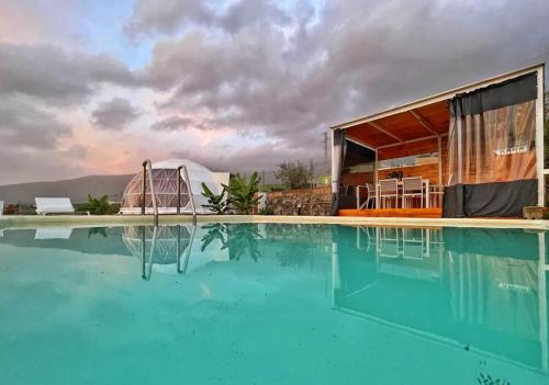 Domo Volcano Suite Experience في Arafo: منزل به مسبح ومبنى