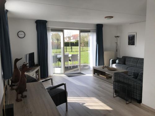 a living room with a couch and a table at Kustverhuur, Park Scheldeveste, Zwin 116 in Breskens