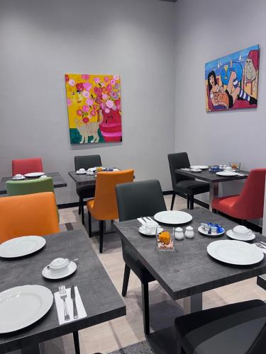 a dining room with tables and chairs and a painting at Apartment Hotel KRAL - BUSINESS HOTEL & SERVICED APARTMENTS in Erlangen