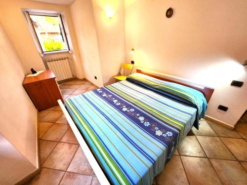 a small bedroom with a bed with a striped blanket at Casa Monti in Pignone