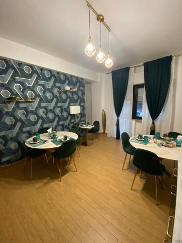 una sala da pranzo con tavoli, sedie e un muro di B&B Smeralda a Villa San Giovanni