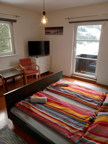 ein großes Bett in einem Zimmer mit einem großen Fenster in der Unterkunft Chalet Rosemarie in Bad Gastein