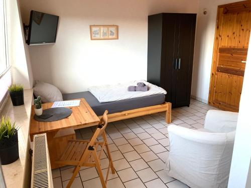Habitación con cama, escritorio y mesa. en Appartementhaus Schlagstein App1 en Kreuzau