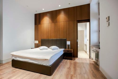 ワルシャワにあるレジデンス 1898の大きなベッドと木製の壁が備わるベッドルーム1室が備わります。