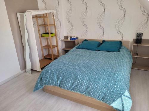 une chambre avec un lit avec une couette bleue dans l'établissement Chez Aurélie et Nicolas, à Brest