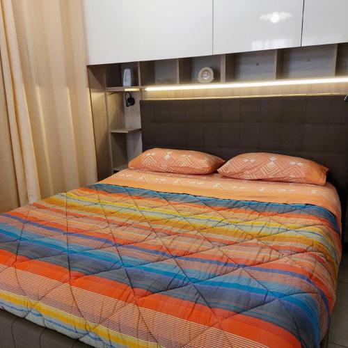 un letto con una coperta colorata e due cuscini di Monolocale in Via Flaminia - Alloggio Turistico a Roma