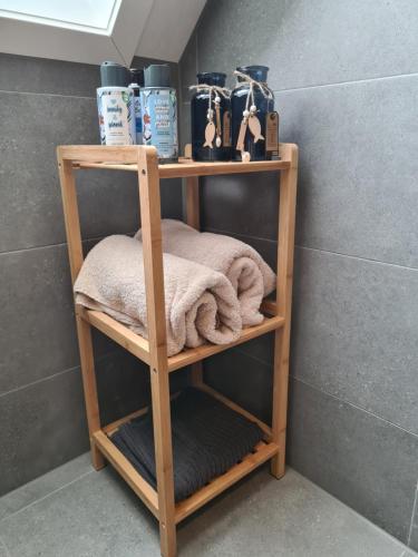 a wooden shelf with towels on it in a bathroom at De WiedenWeide in Wanneperveen