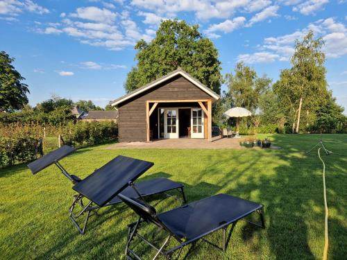 a house with two chairs and a cabin at De WiedenWeide in Wanneperveen