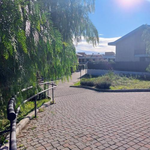 un passaggio in mattoni con una recinzione e un albero di Monolocale in Via Flaminia - Alloggio Turistico a Roma