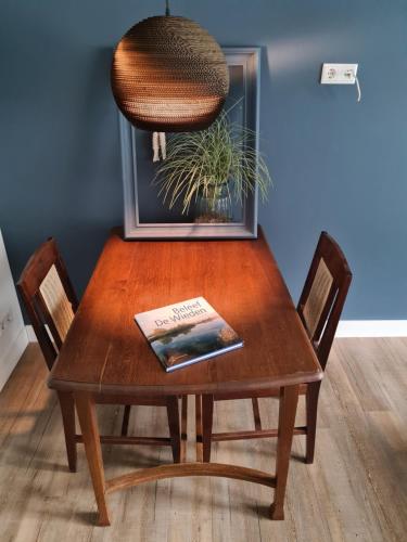 a wooden table with a book on top of it at De WiedenWeide in Wanneperveen